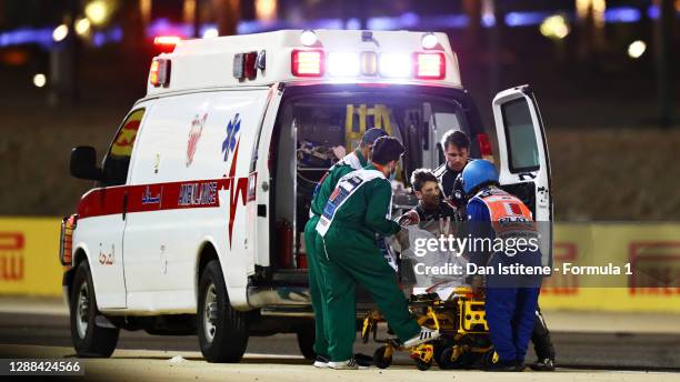 Romain Grosjean of France and Haas F1 is pictured being helped into an ambulance after a crash during the F1 Grand Prix of Bahrain at Bahrain...