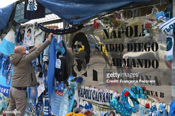 Fan is seen placing tributes to the deceased Diego Maradona outside the stadium prior to the Serie A match between SSC Napoli and AS Roma at Stadio...