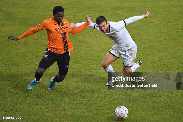 Ephron Mason-Clark of Barnet battles for possession with Daniel Harvie of Milton Keynes Dons during the Emirates FA Cup Second Round match between...