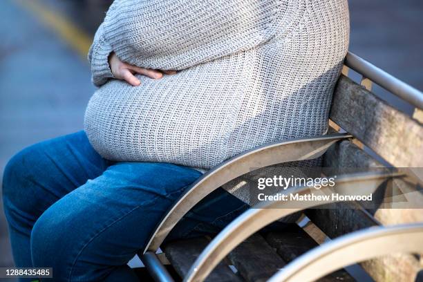 An overweight man sits on a bench on November 27, 2020 in Cardiff, Wales.