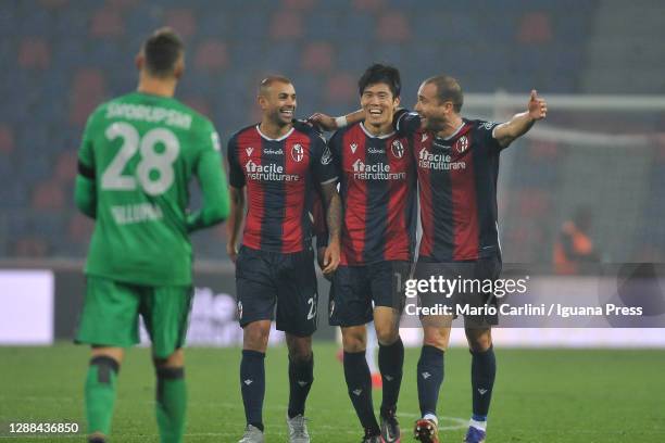 Danilo, Takehiro Tomiyasu and Lorenzo De Silvestri of Bologna FC walk towards their goalkeeper Lukasz Skorupski as they celebrate at the end of the...