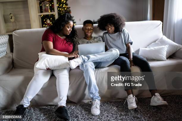 friends sitting on a couch using laptop at home - free download photo stock pictures, royalty-free photos & images