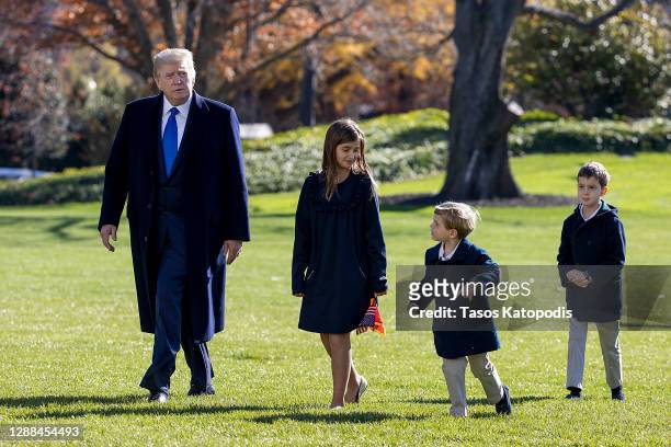 President Donald Trump, followed by his grandchildren, Arabella Kushner, Theodore Kushner, and Joseph Kushner walk on the south lawn of the White...