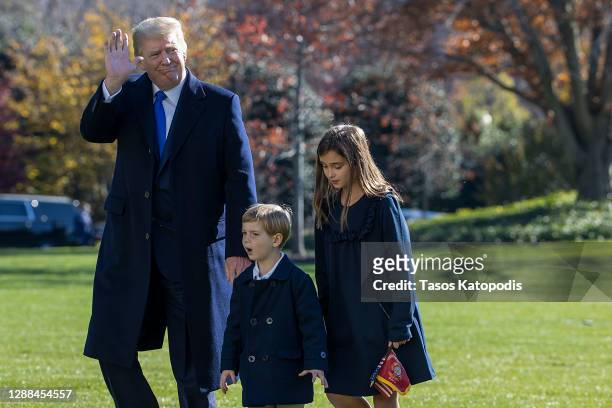 President Donald Trump, followed by his grandchildren, Arabella Kushner, Theodore Kushner walk on the south lawn of the White House on November 29,...