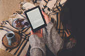 Caucasian woman reading an e-book in the e-book reader.