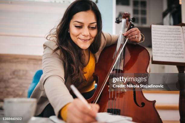 de muzikant stemt de cello af - bow musical equipment stockfoto's en -beelden