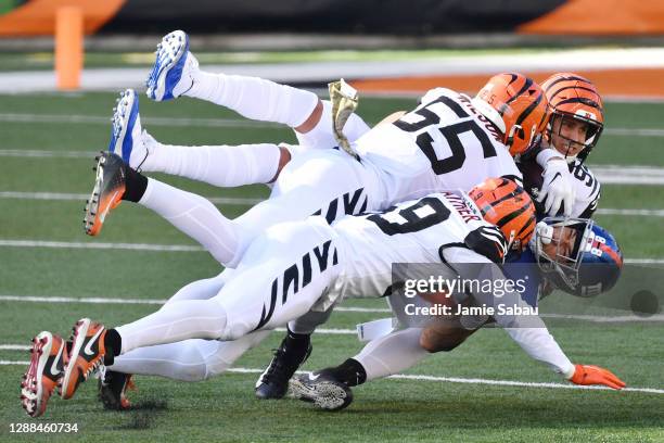 Akeem Davis-Gaither, Logan Wilson, and Sam Hubbard of the Cincinnati Bengals tackle Evan Engram of the New York Giants during the first half at Paul...