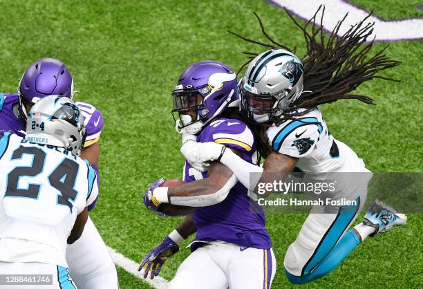 Tre Boston of the Carolina Panthers tackles Dalvin Cook of the Minnesota Vikings during the first quarter at U.S. Bank Stadium on November 29, 2020...