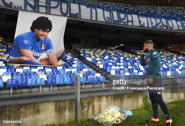 Lorenzo Insigne of S.S.C. Napoli places tributes next to a banner showing an images of the deceased Diego Maradona during the Serie A match between...