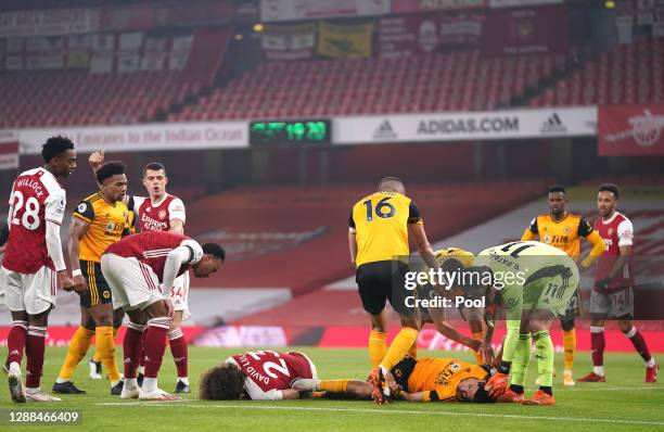 David Luiz of Arsenal and Raul Jimenez of Wolverhampton Wanderers lie injured after a collision during the Premier League match between Arsenal and...