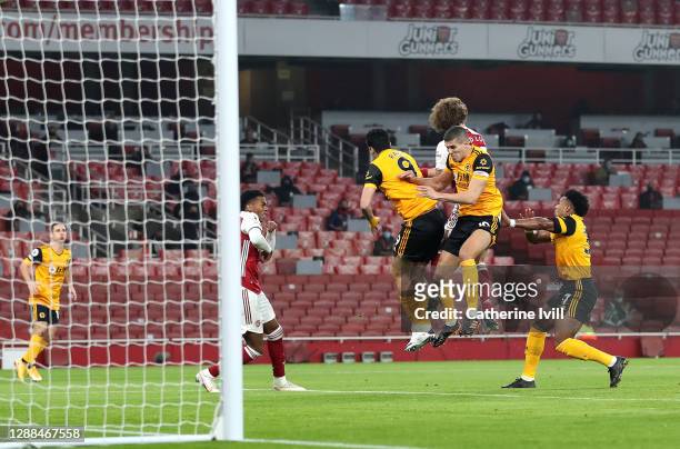 Raul Jimenez and Conor Coady of Wolverhampton Wanderers collide with David Luiz of Arsenal during the Premier League match between Arsenal and...