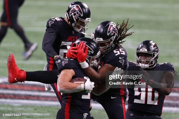 Jacob Tuioti-Mariner of the Atlanta Falcons celebrates with teammates after forcing and recovering a fumble by Derek Carr of the Las Vegas Raiders in...