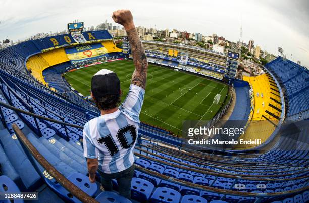 Fan of Diego Maradona raises his fist at the top of the stands of Alberto J. Armando stadium before a match between Boca Juniors and Newell's Old...