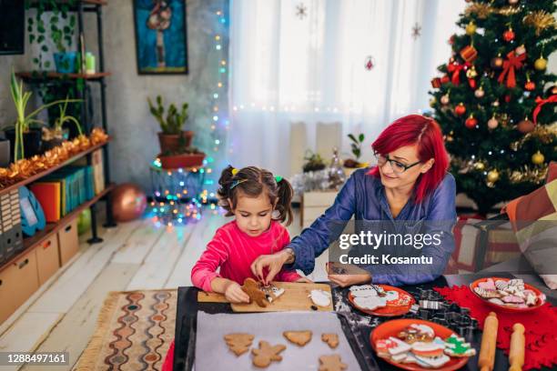 mother and daughter having so much fun while decorating a christmas cookies - 2 5 months stock pictures, royalty-free photos & images