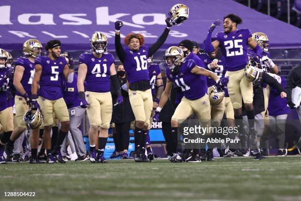 Jalen McMillan of the Washington Huskies celebrates with teammates as the clock expires to secure their 24-21 win against the Utah Utes at Husky...