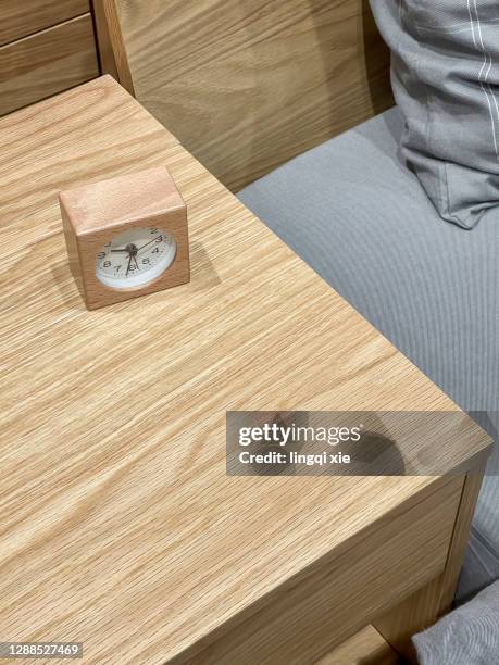 wooden alarm clock on the bedside table in the bedroom - alarm clock on nightstand stock pictures, royalty-free photos & images