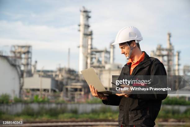 engineer using tablet near oil refinery at night. - refinery fotografías e imágenes de stock