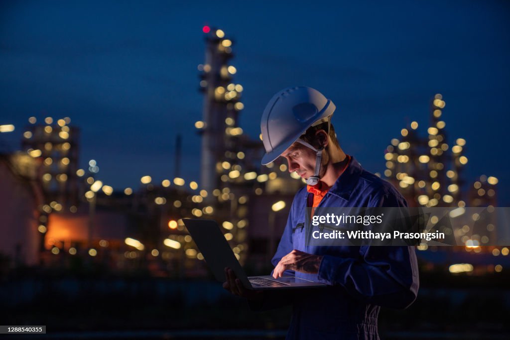 Man Engineer Using Digital Tablet Working Late Night Shift At Petroleum ...