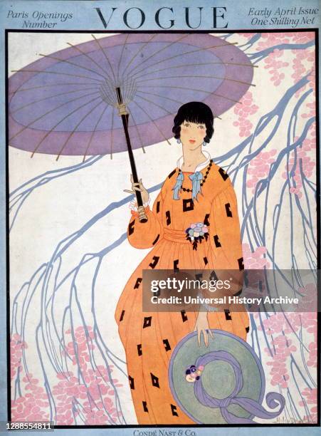 Front cover of vogue magazine, early April issue, published by Cond Nast and Co., London; a lady holds a parasol under a tree and wears an orange...
