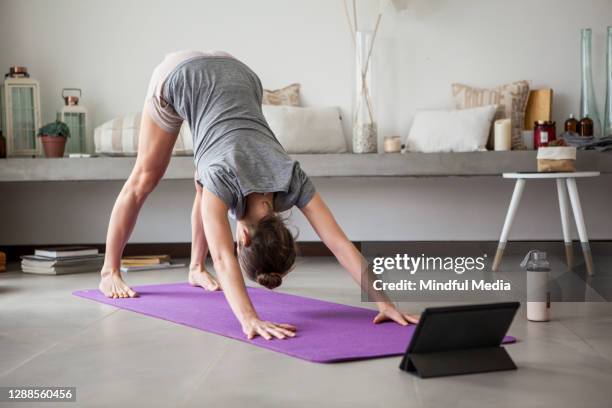 frau macht yoga drinnen - yoga kissen stock-fotos und bilder