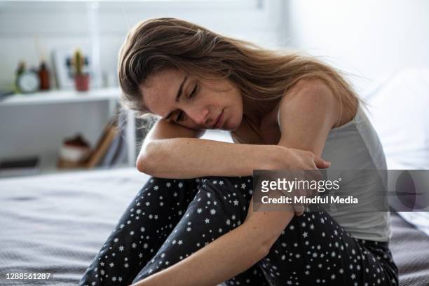 nadenkende vrouwenzitting in slaapkamer - lang fysieke beschrijving stockfoto's en -beelden