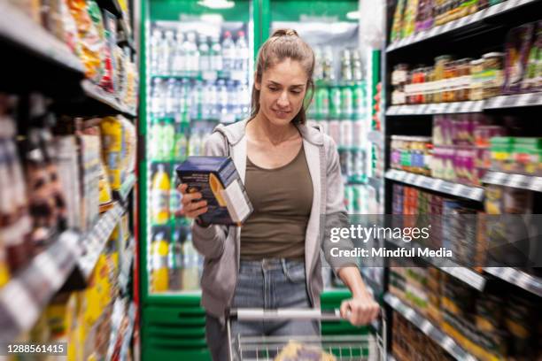 woman shopping in supermarket - long line grocery store stock pictures, royalty-free photos & images