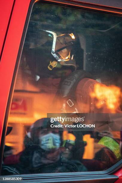 Reflet d'un pompier en intervention et d'un manifestant sur une vitre d'une voiture lors de la marche des libertés contre la loi "sécurité globale"...