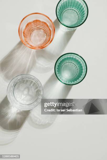 close-up of glasses of water with back lighting. minimal concept - cup of water stockfoto's en -beelden