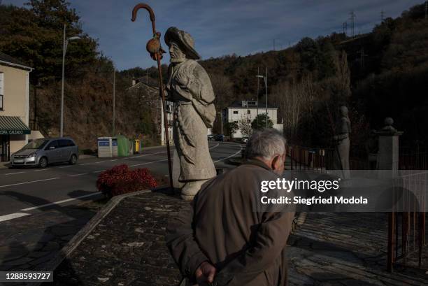 Man walks past the statue of a pilgrim on the Way of St. James, or El Camino de Santiago, a network of ancient pilgrim routes that stretch across...