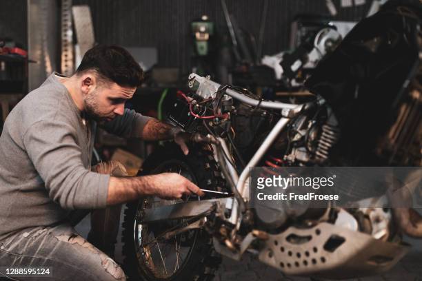 jovem conserta moto moto moto em oficina - corrida de motocicleta - fotografias e filmes do acervo
