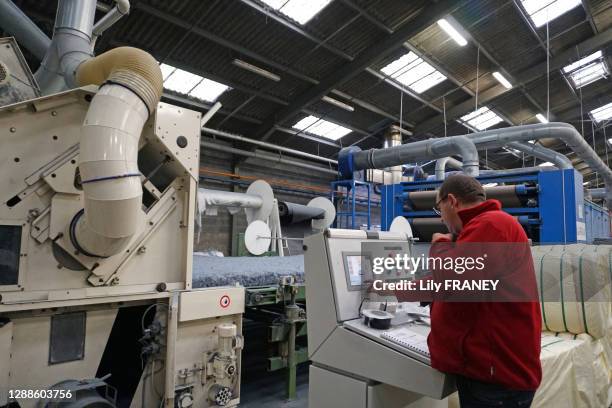 Ouvrier à un poste de travail, recyclage de jeans et pantalons hors usage dans une gamme d'isolation thermique et acoustique en coton pour le...