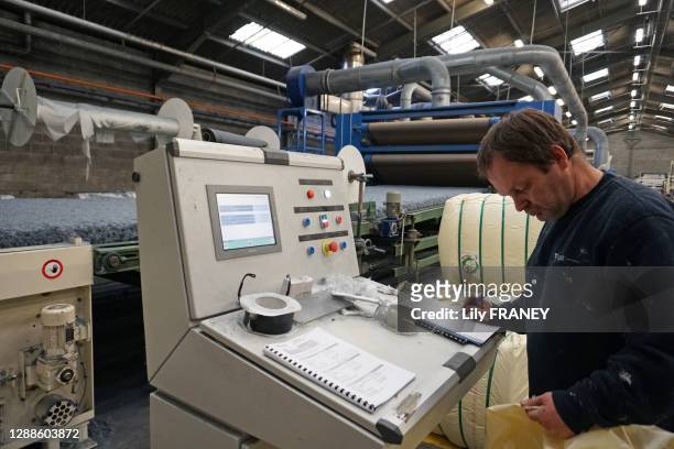 Ouvrier à son poste de travail, recyclage de jeans et pantalons hors usage dans une gamme d'isolation thermique et acoustique en coton pour le...