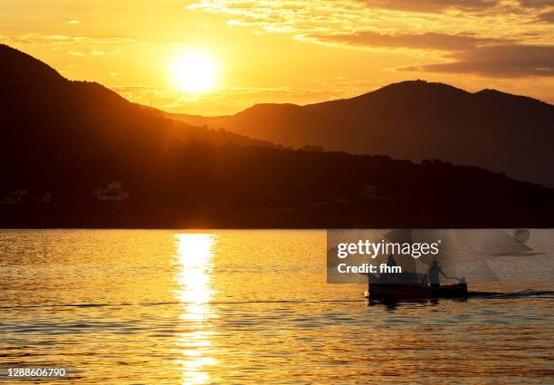 idyllic sunset with fishing boat - fischerboot stock-fotos und bilder