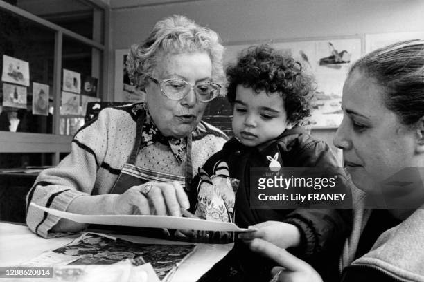 Femme retraitée montrant son dessin à un enfant, lors d'une visite d'une classe maternelle, EHPAD, maison de retraite de Vitry-sur-Seine,...