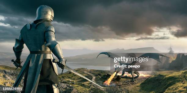 knight looks down on huge dragon breathing fire near castle - knight person stock pictures, royalty-free photos & images