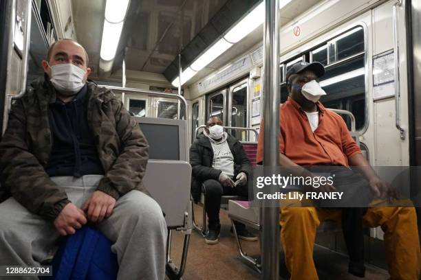 Métro parisien, ligne 11, passagers portant des masques et respectant la distanciation sociale durant le confinement suite au Coranavirus COVID-19,...