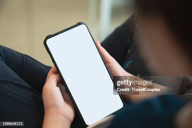 girl hold telephone in hand and playing smartphone watching cartoons at the school. asia child addicted to games problems of children use smartphone technology - child hand stock pictures, royalty-free photos & images