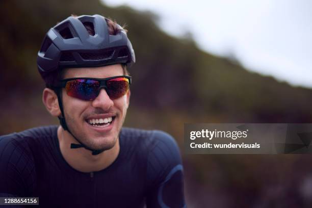 young cyclist smiling with helmet and sunglasses - man sunglasses face imagens e fotografias de stock