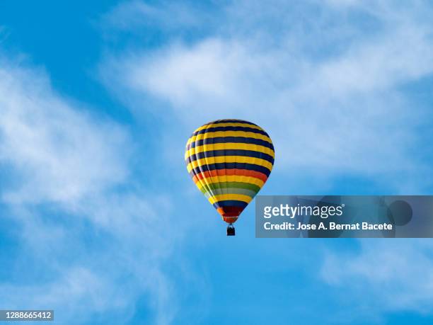 a hot air balloon flying on the blue sky. - hot air balloon ride stock-fotos und bilder