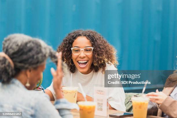 three female friends talk and laugh over iced coffees - iced coffee stock pictures, royalty-free photos & images