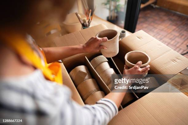 imprenditrice irriconoscibile che impacchetta vasi da fiori in una scatola di cartone - packaging foto e immagini stock