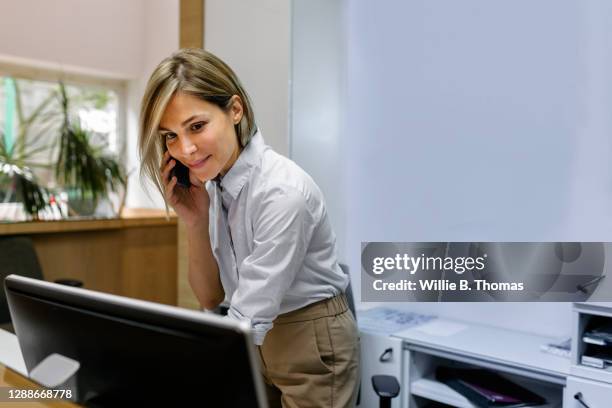 hotel receptionist busy working behind front desk - reception stock pictures, royalty-free photos & images