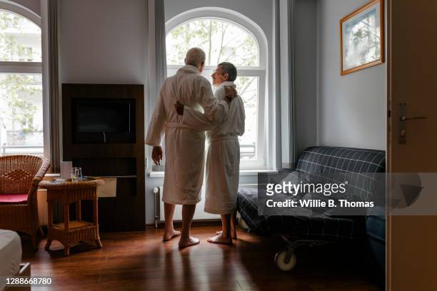 mature gay couple spending time alone at hotel together - gay seniors fotografías e imágenes de stock