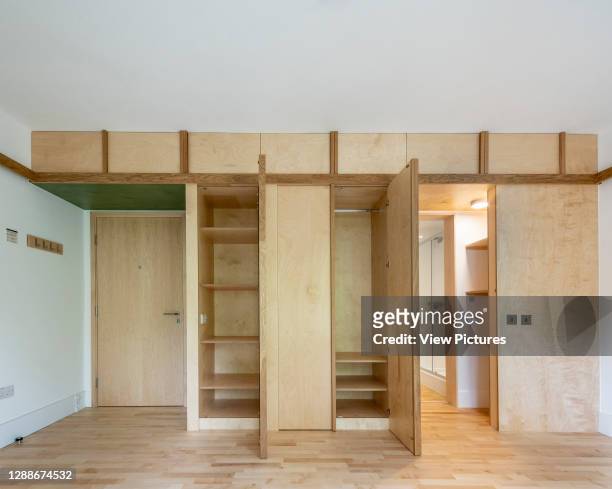 Bedroom interior fitted wardrobe open. Churchill College Cambridge Student Housing, Cambridge, United Kingdom. Architect: Cottrell + Vermeulen...