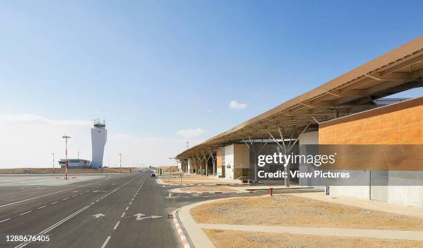 Exterior view with Air Traffic Control Tower in the distance. Ramon Airport, Eilat, Israel. Architect: Mann Shinar Architects, 2019.
