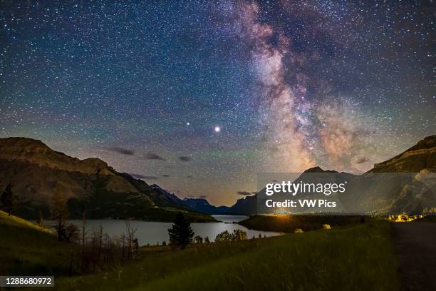 The galactic core area of the Milky Way over Waterton Lakes National Park, Alberta with the pairing of giant planets from summer 2020. Jupiter is the...