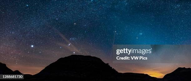 Orion and the winter stars setting on a spring evening at Dinosaur Provincial Park, Alberta, with the Zodiacal Light rising out the urban sky glow...