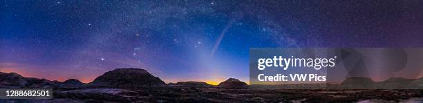 Wide panorama of Orion and the winter stars setting on a spring evening at Dinosaur Provincial Park, with the Zodiacal Light rising out of the...