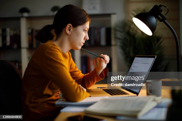 serious teenage girl studying late at home - studying hard stock pictures, royalty-free photos & images