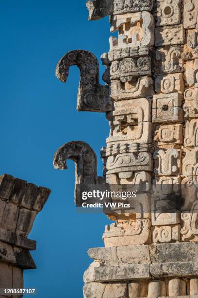 Carved stone Chaac masks with their curling noses on the north building of the Nunnery Quadrangle in the pre-Hispanic Mayan ruins of Uxmal, Mexico.